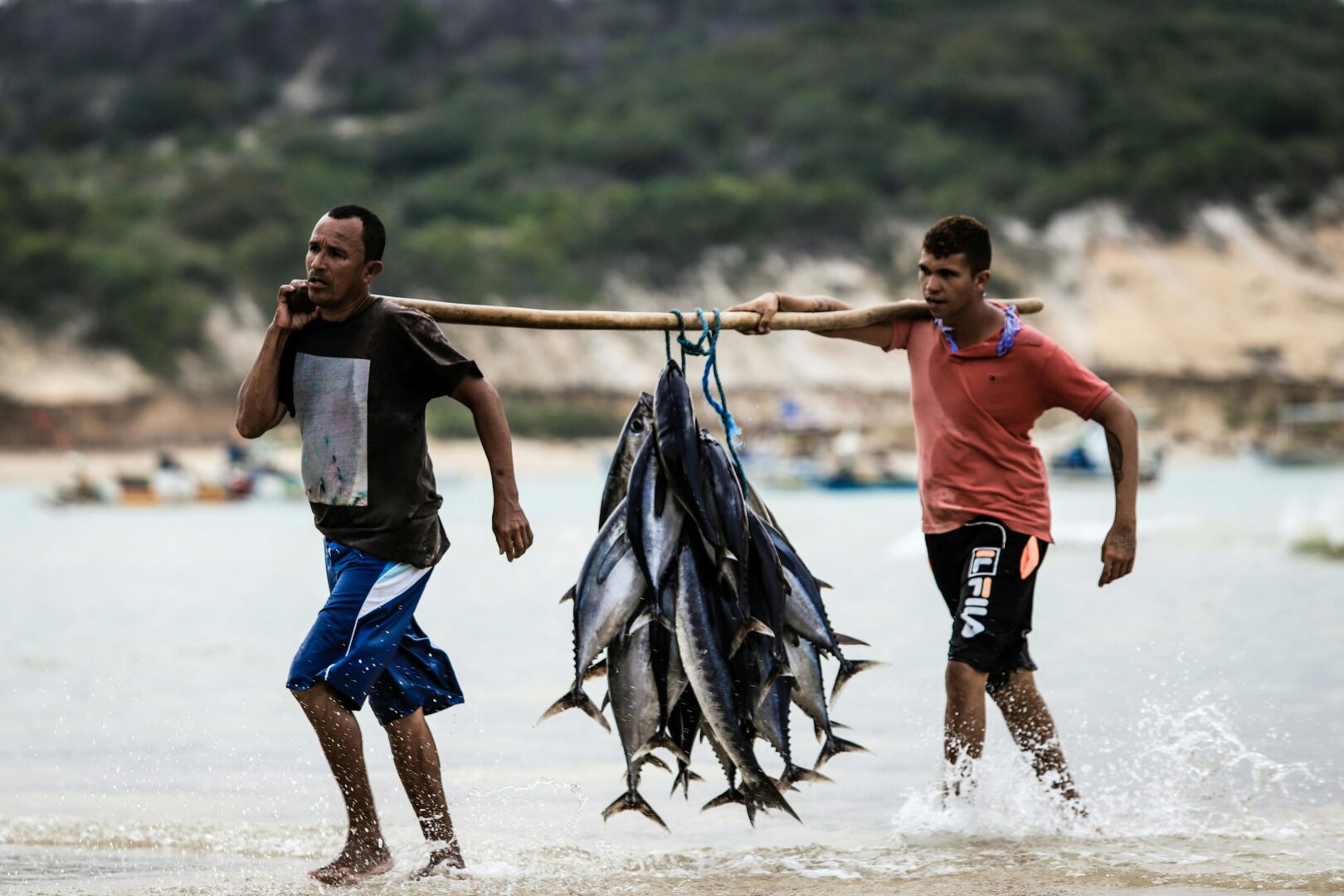 Two men carrying fish